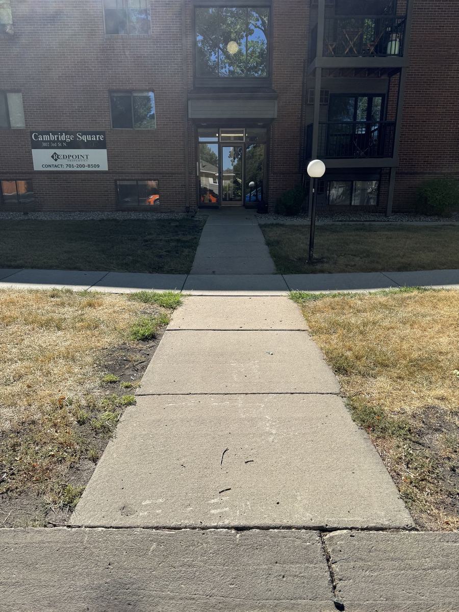 Cracked, aging apartment sidewalk before replacement