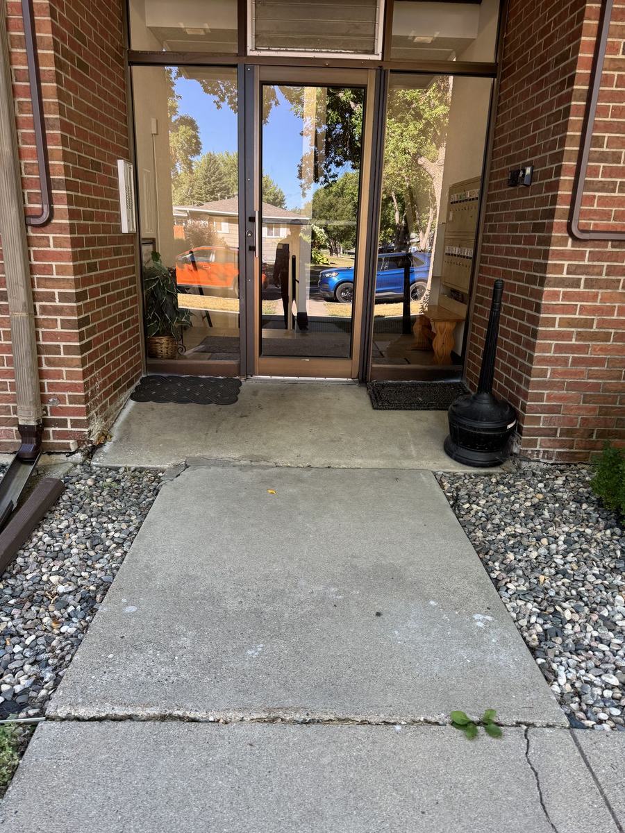 New concrete entry walk at a brick building