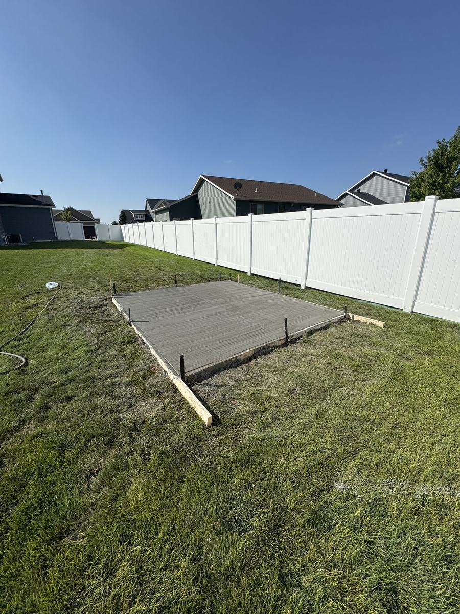 New concrete slab in a fenced backyard